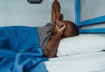 Sono ruim e má alimentação afetam músculos e peso pessoa deitada na cama com sono