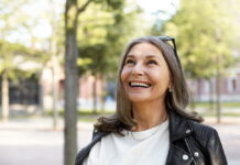 Medicina regenerativa fortalece a saúde e favorece a longevidade Mulher madura sorrindo durante caminhada ao ar livre