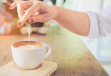 Adoçantes fazem mal? Veja quando é preciso atenção pessoa colocando adoçante no café