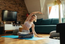 como adaptar os exercícios após o tratamento Mulher realizando alongamento em casa